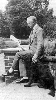 Picture of F. M. Alexander, reading a book with his dog beside him