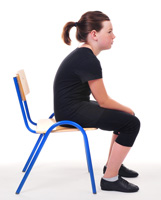 Young girl sitting on a school chair with rounded back
